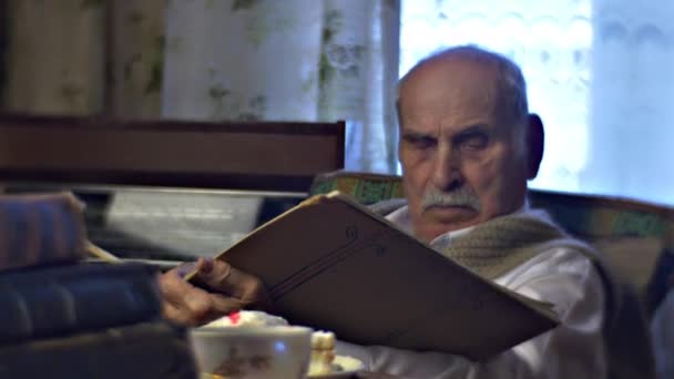 Viejo inteligente en acogedora sala de estilo soviético Abuelo le encanta leer Hojas a través del álbum Documentos Trabajar en casa Consejos anti-envejecimiento Salud — Vídeos de Stock