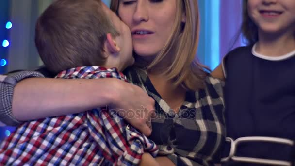 Mutlu anne Hugs Kisses oğlu ve kızı şefkatle Noel tatili evde hamile anne ve onun çocuk gül kumaştan yapılmış iki aile kutluyor — Stok video