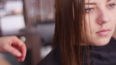 Spa salonunda kadın müşterinin saçını tarayan kuaför.