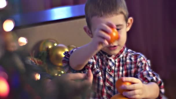 Chico intenta construir un muñeco de nieve de naranjas — Vídeos de Stock