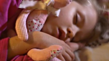 Sevimli küçük çocuk Sleeping Hugs Her Beloved Soft Toys Pink Hand-Made oyuncak ayı ve tavşan yakın görünümü çocuk vardır oynuyor evde ve düşmüş uykuda o