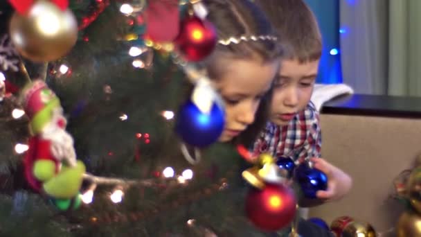 クリスマスの毛皮ツリーの下の子どもの遊び — ストック動画