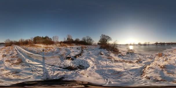 360Vr Vídeo Turismo de Invierno en Polonia Lago Paisaje Rural Nieve pisoteada cubre el camino Sol pone detrás del agua Árboles ramificados desnudos en un campo nevado Horizonte — Vídeos de Stock