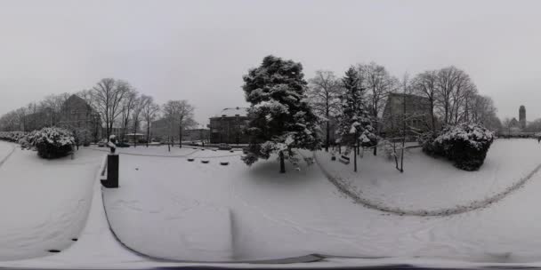 360Vr Vídeo Inverno Cityscape Parque nevado Edifícios e transportes por trás de árvores nuas Pegadas em uma neve vida cotidiana da cidade europeia moderna Crepúsculo — Vídeo de Stock
