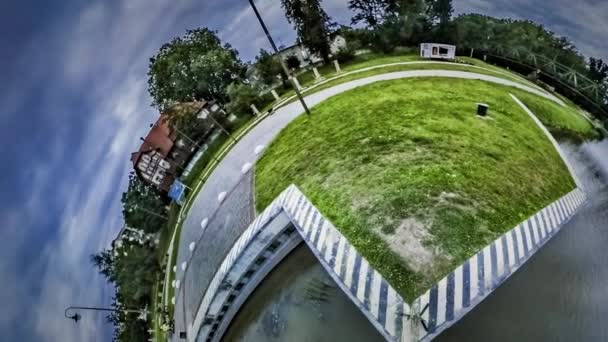 Kleiner winziger Planet 360-Grad-Abend auf dem Fluss Eisenbahnbrücke Rasen und Wasser schöne Wolkenlandschaft in Opole Erde im Raum Natur Zeit vergeht an uns vorbei — Stockvideo