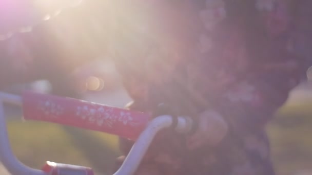 Fille monte sur un vieux vélo pour enfants 