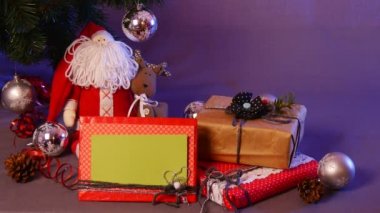 Neşeli Noel oyuncaklar Taken ve köknar ağacı altında koymak, onları iki kutu-arasında kırmızı Santa, fotoğraf çerçevesi, el yapılan topları, çam kozalakları ve benzeri vardır