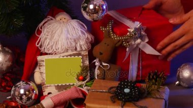 Adam el al'ın ve bir yay ile bazı Noel hediyesi olarak bir kırmızı kutusu ile bir şenlikli şerit bağlı koyun. Yanında bir el yapılan Santa, benekli bir kalp ve benzeri