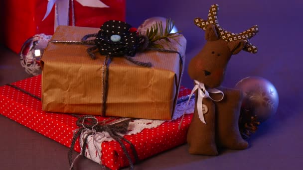 Les mains féminines prennent des jouets faits à la main festifs sous un arbre de Noël décoré, incluent un cadre photo fait à la main, un beau cerf, etc. — Video