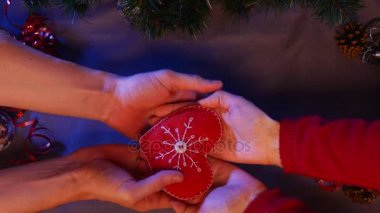 Teslim üzerinden altında Noel ağacı ile çam kozalakları ve el yapılmış renkli yağmur çizgili yalan yakındaki bir güzel el yapılmış kırmızı kalp olduğunu