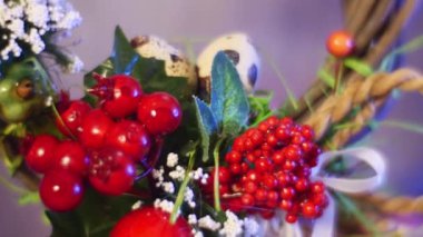 Opole, Poland - Feb 18 2017: a Closeup of Guelder Rose Red Berries and Spring Field Flowers Fixed to a Traditional Easter Brown Ring, One of the Symbols of Catholic Easter, Hanging Over a Table