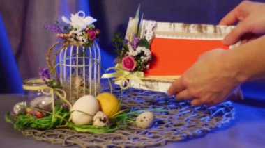 bir portakal fotoğraf çerçevesi koymak yakınındaki bir üst yumurta kafesi ile bir beyaz yayı, tavuk ve bıldırcın yumurtası, bir şişe ile bir mum üzerinde