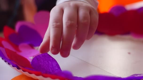 Mädchen klebt ein Stück Papier auf eine Pappplatte — Stockvideo