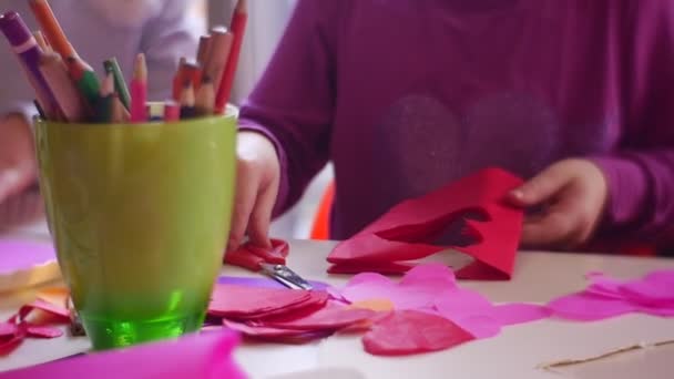 Niño toma una tijera roja de una mesa — Vídeos de Stock