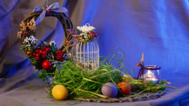 Opole, Poland - Jan 20 2017: Amazing Composition is Made of Easter Hen and Quail Eggs, a Traditional Bottle With a Candle, a Brown Ring, Hanging Over a Round Table, With a Violet Background Behind It