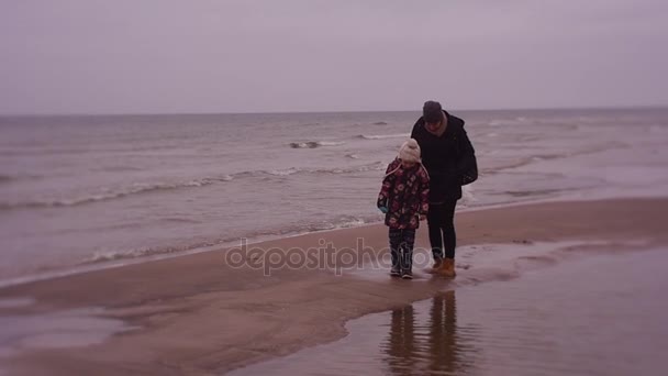 Туристы топчутся на мокром песке на пляже — стоковое видео