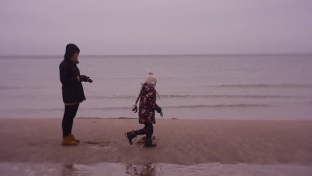 Giovani passeggiate in famiglia sulla spiaggia deserta contro il mare — Video Stock
