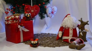 Fotoğraf çerçeveleri etkileyici bir Noel Baba ve kahverengi geyik gibi el baykuş bir çam kozalağı ve diğer oyuncaklar yapılmış onun arkadaşı yakın yerleştirilir