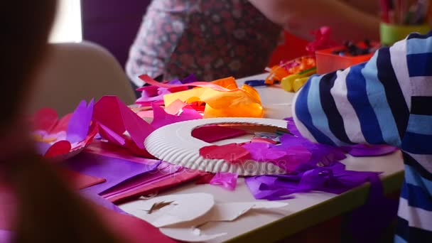 I genitori e i loro figli fanno bei cuori dalla carta colorata per attaccarli ai bianchi vuoti di plastica rotondi per festeggiare San Valentino in slow motion — Video Stock