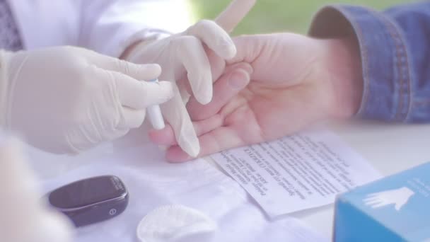 Arzt drückt Tröpfchenblut aus Finger — Stockvideo