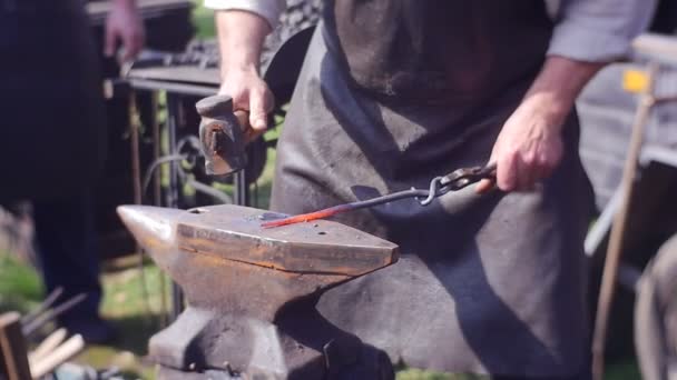 Ο άνθρωπος σε ένα καπέλο είναι ασχολούνται με Blacksmithing — Αρχείο Βίντεο