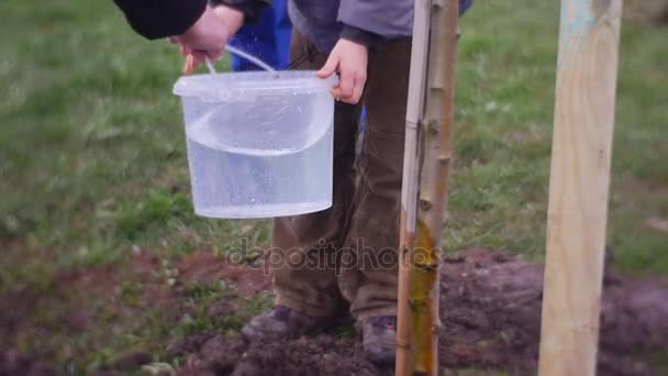 Hombre toma lejos un cubo con agua a chico — Vídeo de stock