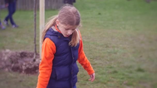 Девушка носит пластиковое ведро, наполненное водой — стоковое видео