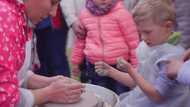 Chłopiec przygląda się gliny, które przyklejone do jego rąk — Wideo stockowe