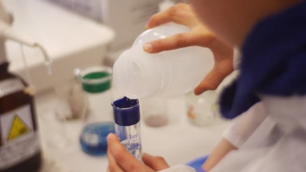 Лабораторный помощник проводит химические эксперименты в лаборатории — стоковое видео