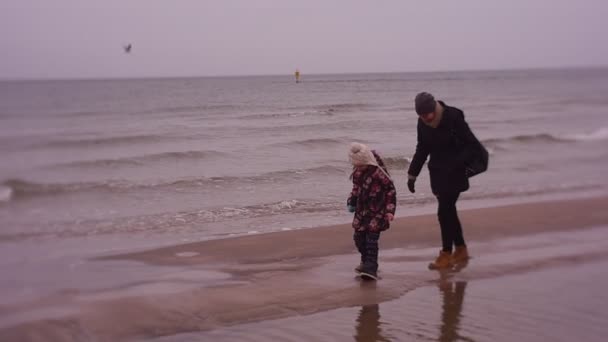 Madre imita un bambino, va per sua figlia su sabbie mobili, Vacanza invernale in mare — Video Stock