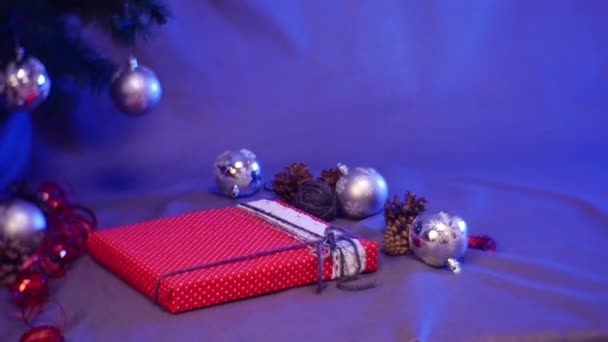 Uma mulher prepara surpresas de Natal e coloca as caixas em uma pirâmide sob a árvore de ano novo — Vídeo de Stock