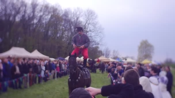 Mens in traditionele Poolse kleren rijdt een paard — Stockvideo