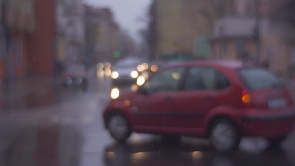 La encrucijada de la carretera de la ciudad en tiempo nublado lluvioso, coches en la encrucijada están esperando la luz verde. No en foco — Vídeo de stock