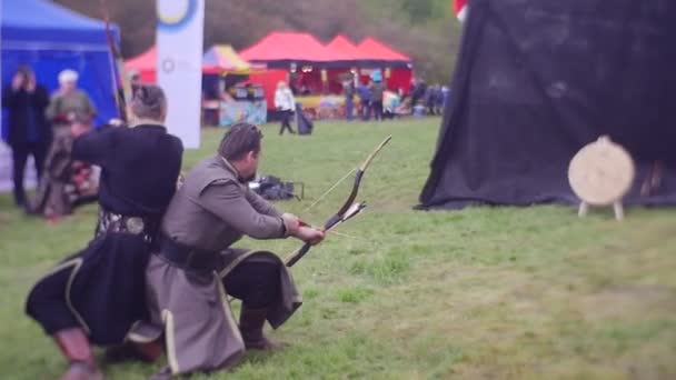 Freunde auf einem Schlachtfeld Duell zweier Bogenschützen Männer schießen in ein Ziel Turnier der Ritter in Opole historische Nachstellung mittelalterlicher Marktunterhaltung — Stockvideo