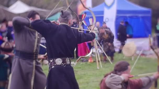 Чотири лучників одночасно знімати до цільової турнір лицарів в Ополе середньовічних воїнів європейських працюють глядачі дивитися і фотографувати — стокове відео