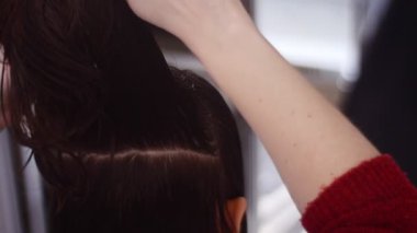 Spa salonunda kadın müşterinin saçını tarayan kuaför.