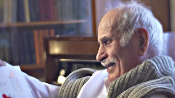 Старший Кавказький Чоловік Читає Розмитий Текст Вдома — стокове відео