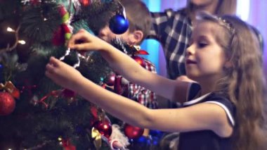 Aile evdeki Noel ağacını süslüyor.
