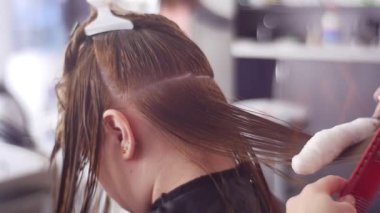 Spa salonunda kadın müşterinin saçını tarayan kuaför.