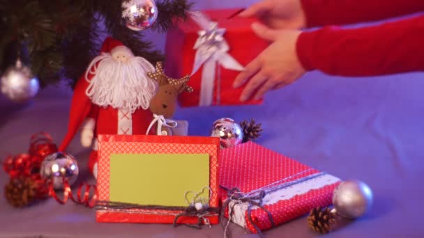 여자의 크리스마스 선물을 장식된 아래에 손으로 반짝이는 줄무늬와 손으로 — 비디오