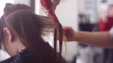 Spa salonunda kadın müşterinin saçını tarayan kuaför.