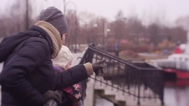 Anne ve kızı soğuk sonbahar ya da kış günlerinde birlikte deniz limanında vakit geçirirler.