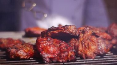 Bir Restoran Müşterileri İçin Kızarmış Et Dilimleri Hazırlıyor. Küçük bir metal ızgarada kızartılıyorlar. Düzenli aralıklarla aşçı eti farklı yönlerden kızartır.