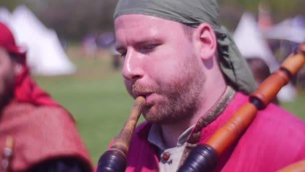 L'uomo adulto sta giocando su una vecchia cornamusa di legno — Video Stock