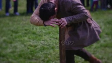 Genç bir adam bir ahşap sütun çalışır