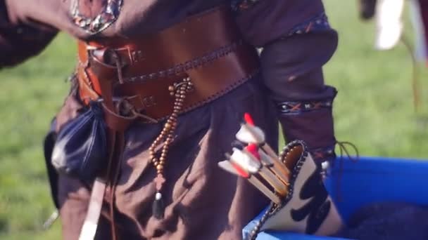 Лучник, одетый в доспехи, носит трофеи — стоковое видео