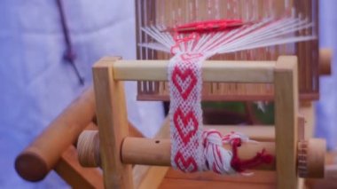 Hangi üzerinde dokuma yatıyor üzerinde Süsle bir şerit dokuma tezgâhı. Halk el sanatları Fuarı'nda gösterilen