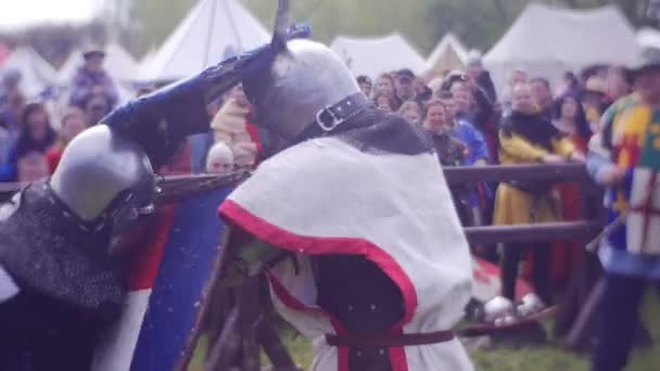 Grande cavaleiro empurra pequeno cavaleiro com escudo pesado — Vídeo de Stock