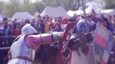 İnce bir şövalye tarafından geniş bir kırmızı kalkan savundu