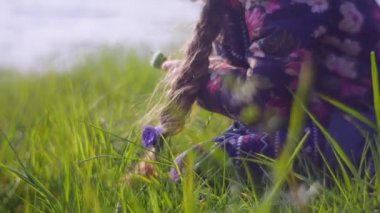 Kızıl saçlı kız yumuşak yeşil çimenlerin üzerinde oturuyor